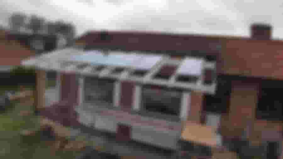 Inkomplett glastak med öppningsbara paneler under konstruktion.