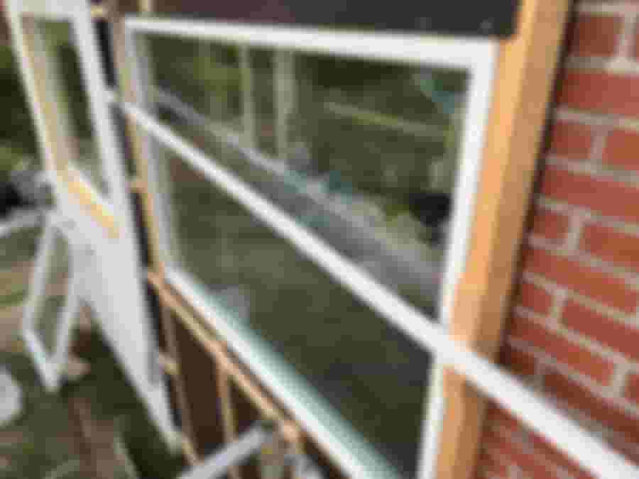 Renovering av fönster med synliga trästommar och verktyg i bakgrunden, vilket visar på pågående inrednings- och renoveringsarbete.