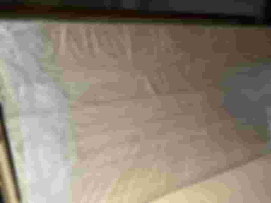 Stort träskiva täckt med plast, redo för montering eller snickeriprojekt. Perfekt för att skapa en modern och naturlig inredning.