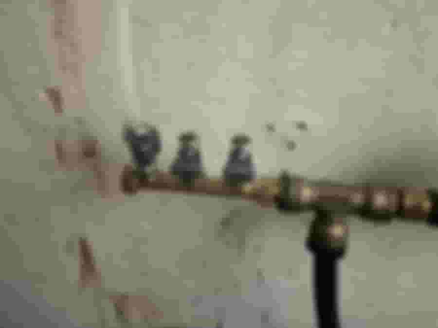 Väggmonterad rörkoppling med ventiler mot en sliten, vitmålad vägg. Perfekt för att optimera vattenflödet i renoveringsprojekt.