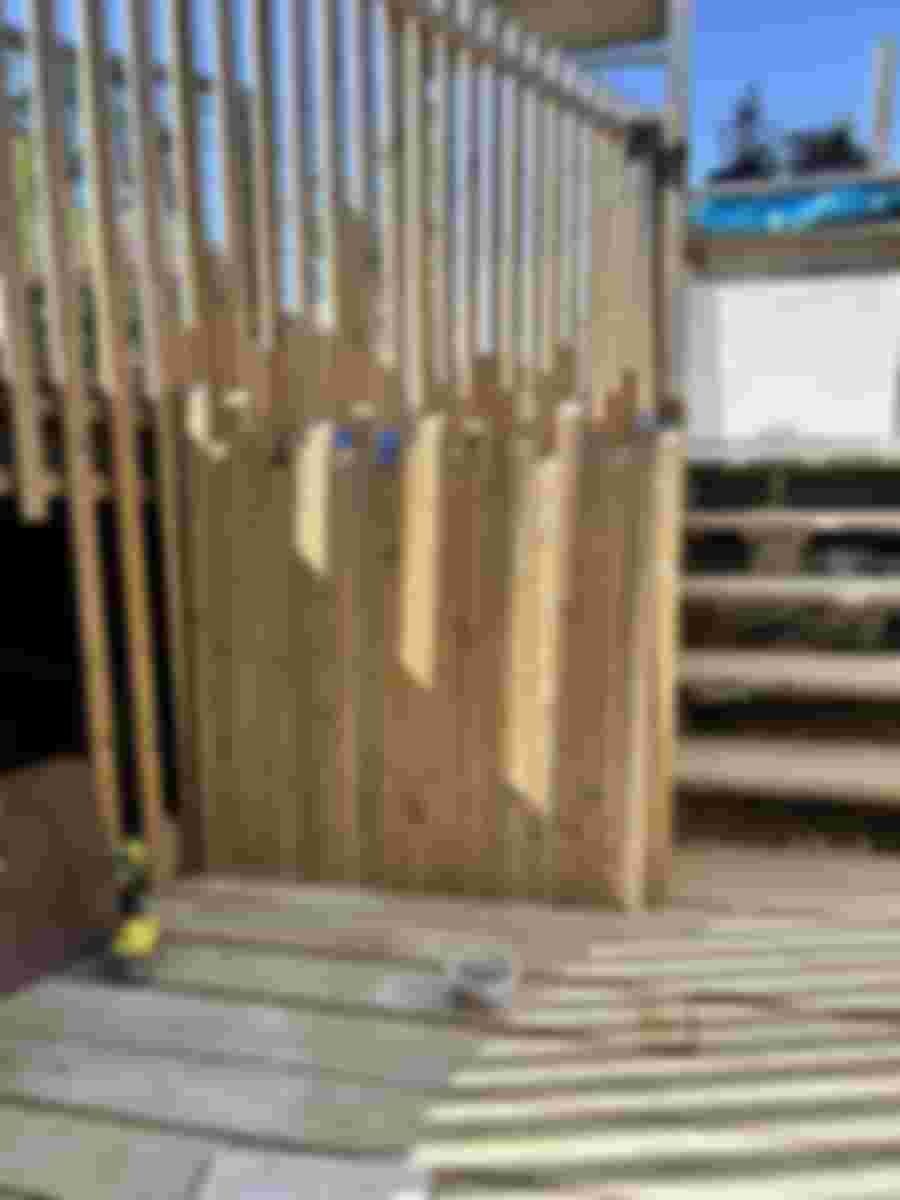 Nyligen byggt staket av trä med trappor i bakgrunden.