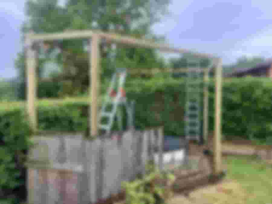 Konstruktion av en ram för badtunna med stege och verktyg.