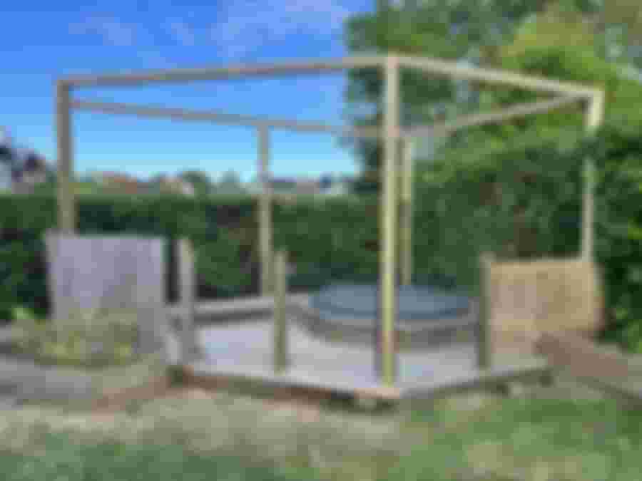 Nytt staket och glasade grinden installerade runt badtunnans plattform i trädgården.