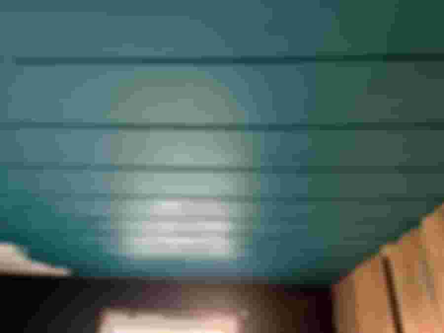 Målat tak i turkos färg, omgivning med svarta väggar.